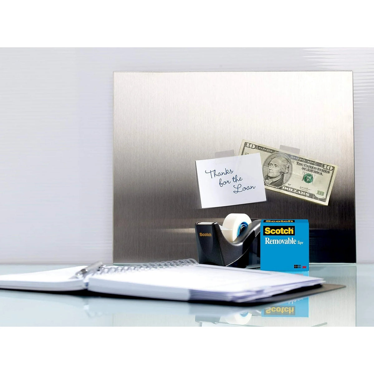 Fridge with a magnet, tape, and a note on a white surface